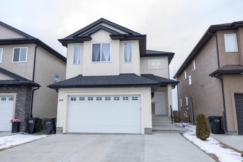 a white garage door in front of a house at Luxurious home, Sleeps 13, Minutes off Anthony Henday, Shopping, Restaraunts, Casino in Edmonton