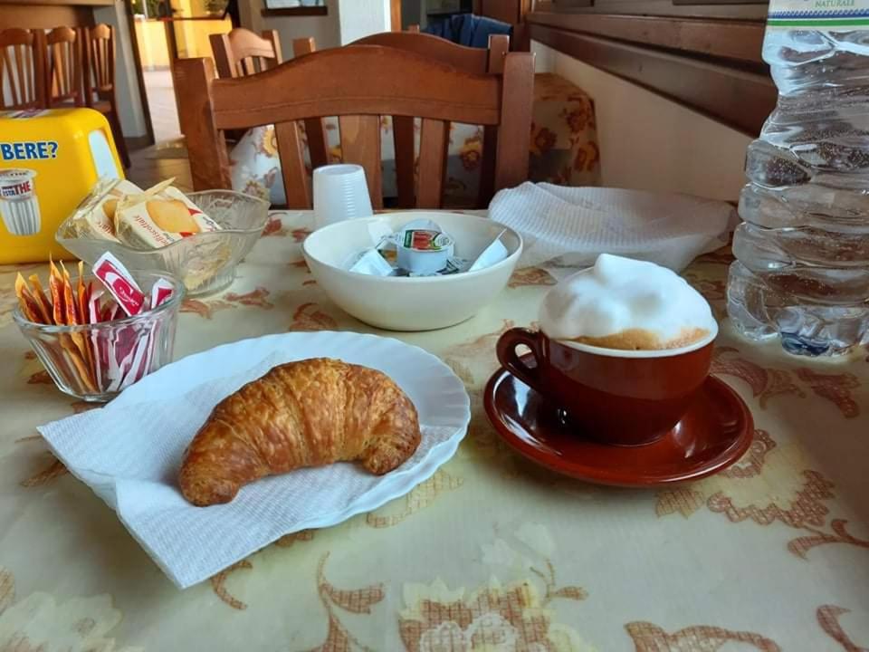 una mesa con una taza de café y un cruasán en B&B A CASA DI MARIO, en San Severino Lucano