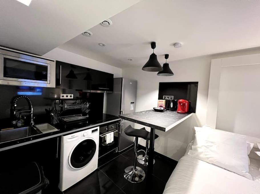 uma cozinha com máquina de lavar e secar roupa num quarto em St Michel studio em Paris