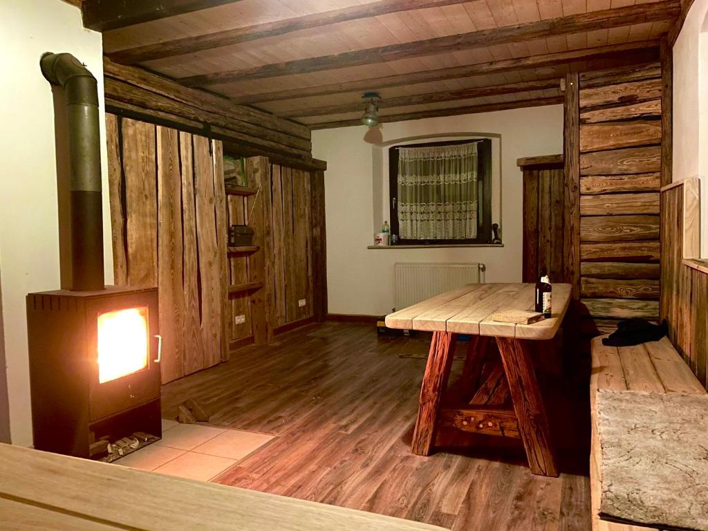 um quarto com uma mesa de madeira e uma lareira em Ferienhaus Linde em Warmensteinach