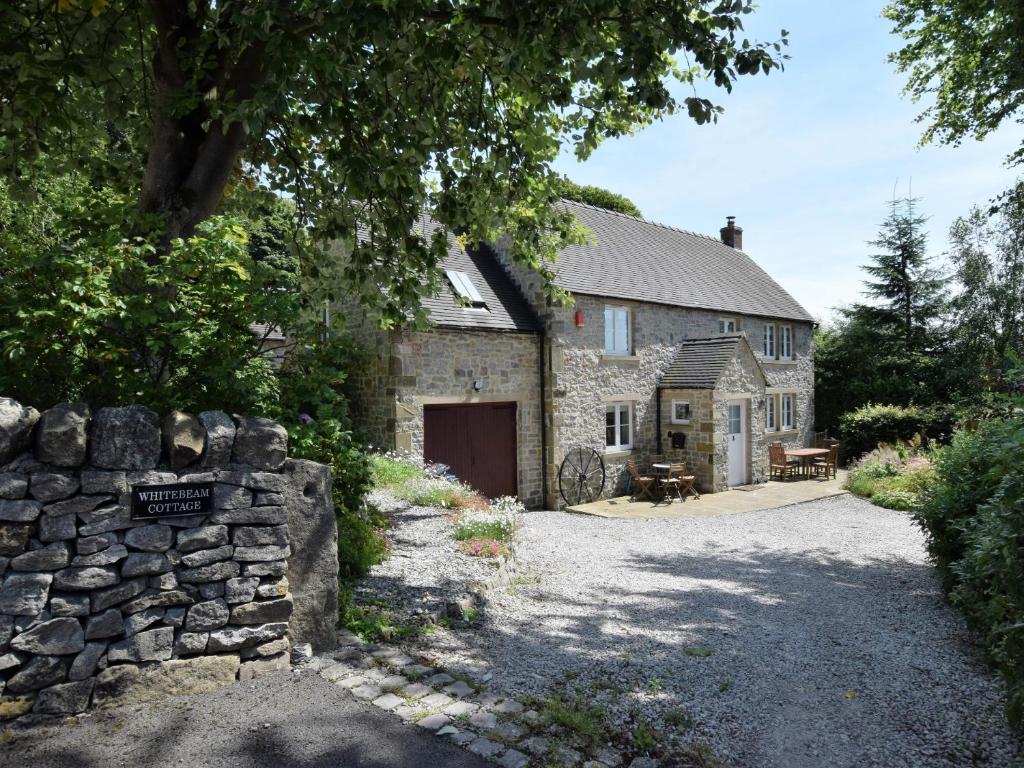 an old stone barn with a stone wall next to it at 4 Bed in Brassington 47450 in Brassington