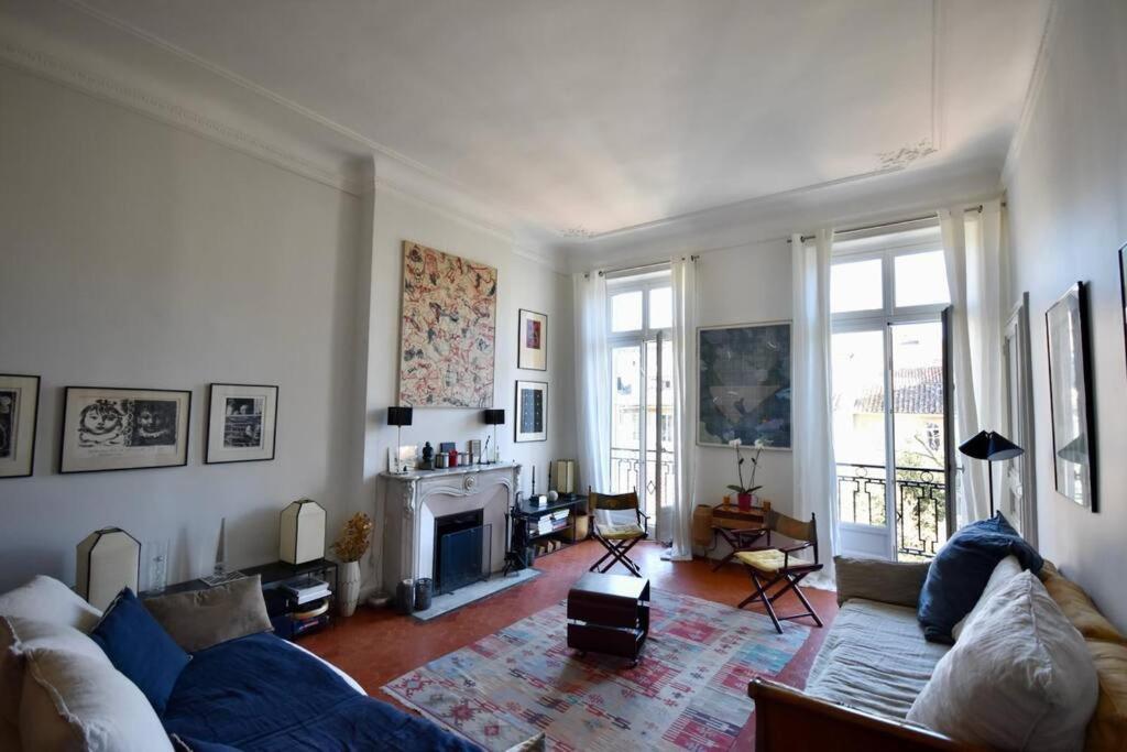 un salon avec un canapé et une cheminée dans l'établissement Coeur Longchamp, Grand Haussmannien, à Marseille