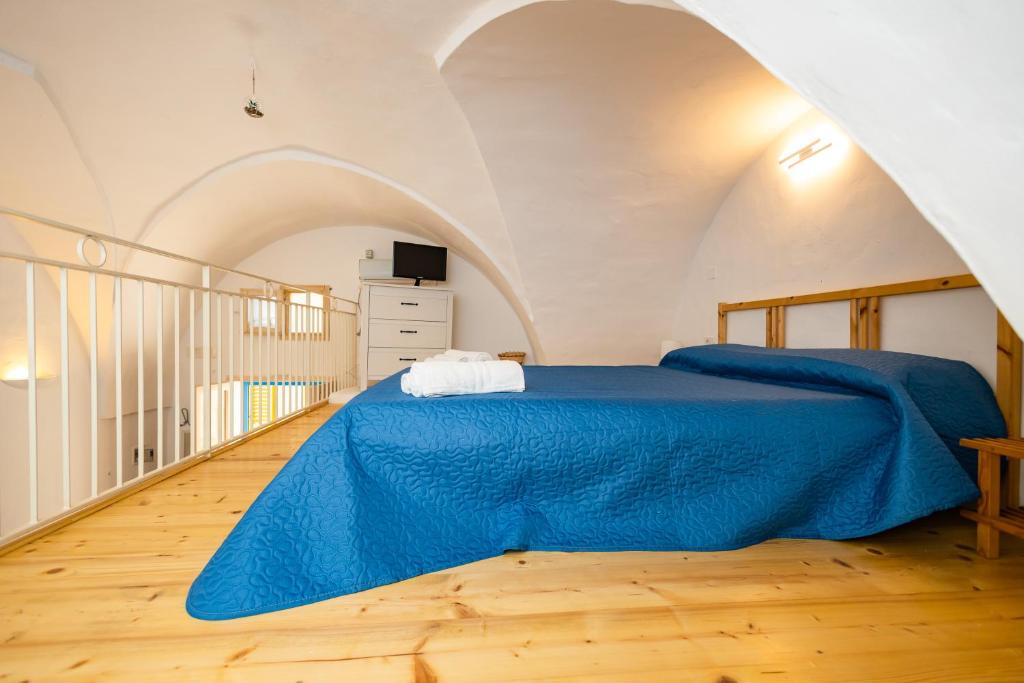 sypialnia z niebieskim łóżkiem na poddaszu w obiekcie Blue Hole w mieście Parabita