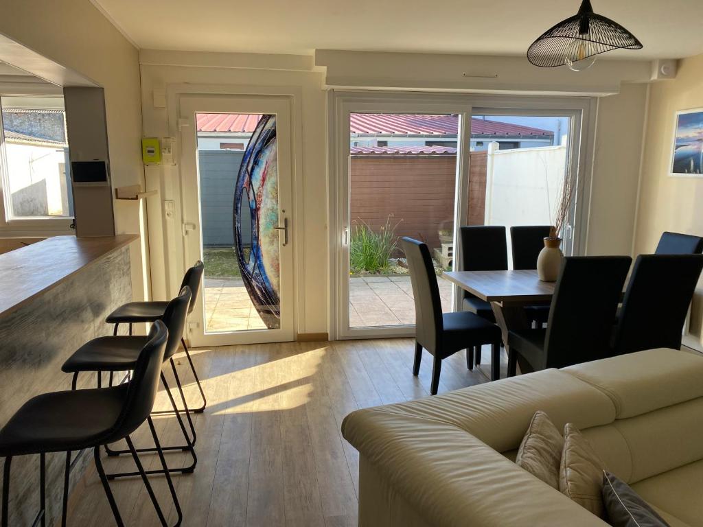 un salon avec un canapé, une table et des chaises dans l'établissement La Petite Allée, à Wimereux