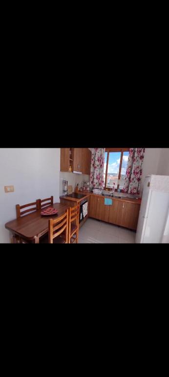 une cuisine avec une table en bois et une salle à manger dans l'établissement Apartament Cornerstone, à Shkodër