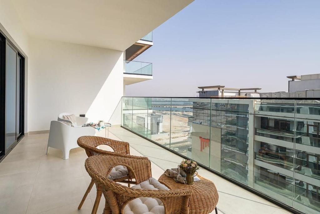 a balcony with wicker chairs and a table on a building at Frank Porter - Binghatti Creek in Dubai