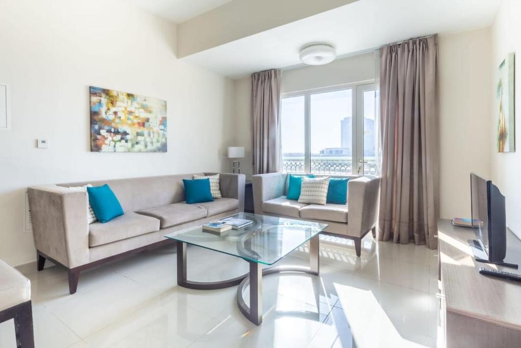 een woonkamer met een bank en een tafel bij Frank Porter - Suburbia in Dubai