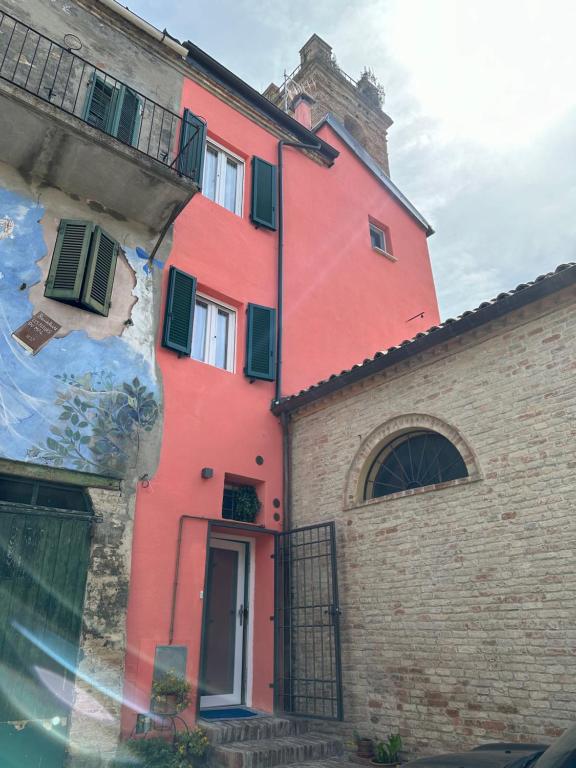 czerwony budynek obok ceglanego budynku w obiekcie B&B Come nelle Favole w mieście Saludecio
