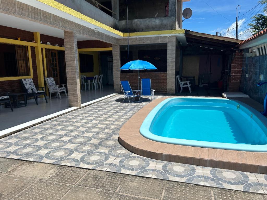 una piscina accanto a una casa con ombrellone di Casa de Lazer Praia e Piscina a São José da Coroa Grande