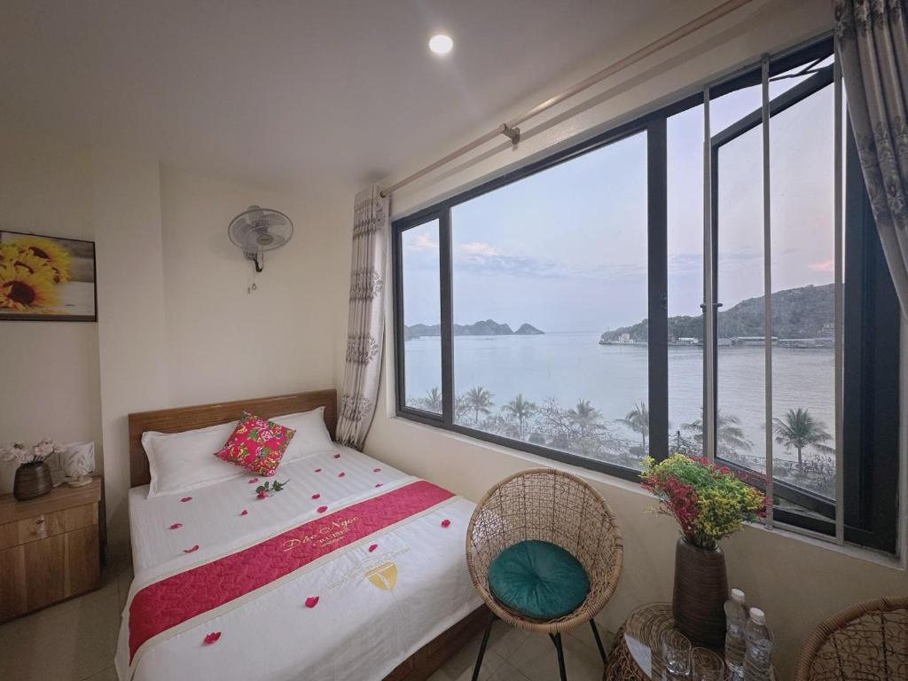 a bedroom with a bed and a large window at GEM HOSTEL in Cat Ba