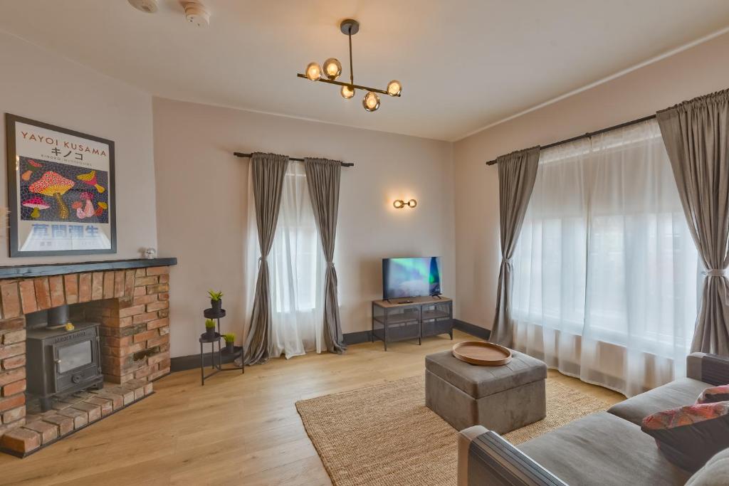 a living room with a fireplace and a tv at Avenue Apartment in Belfast