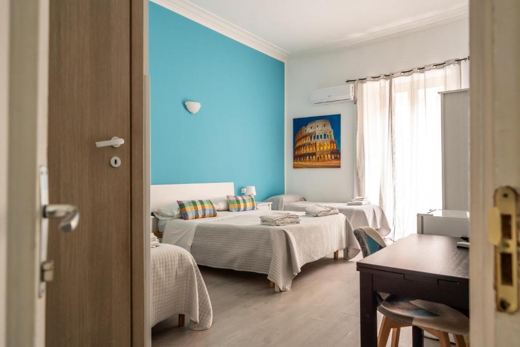 a bedroom with two beds and a blue wall at B&b Glamour in Palermo