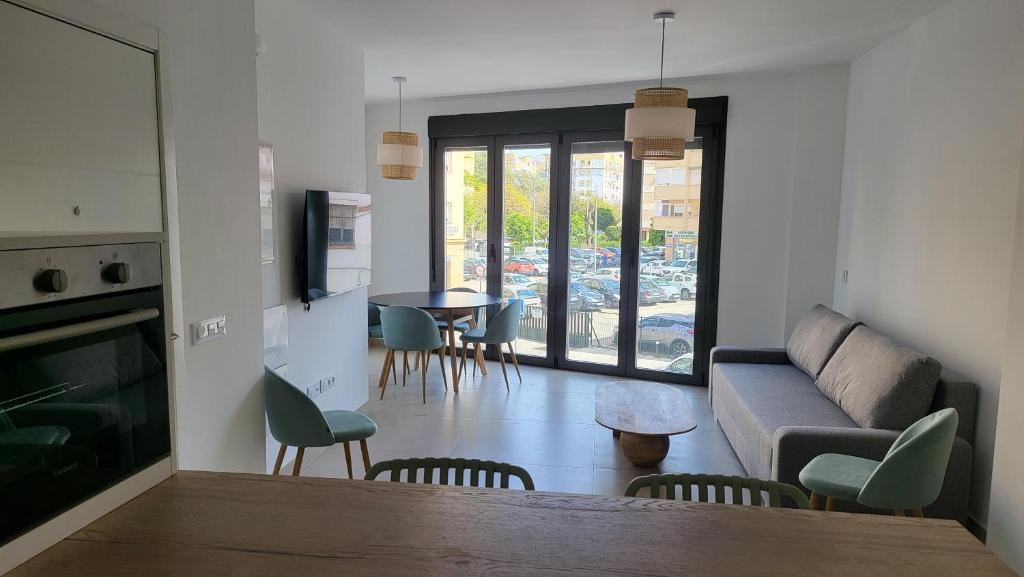 - un salon avec un canapé, une table et des chaises dans l'établissement RentalSevilla La Salle, à Séville