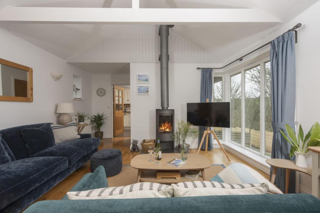 a living room with a blue couch and a tv at Lobbs Cottage, St Mawgan in Saint Mawgan