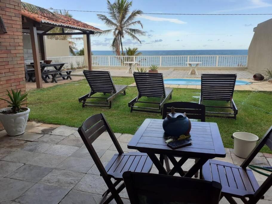 uma mesa com cadeiras e uma tigela em cima em Breeze & Shade Beira Mar em Parnamirim