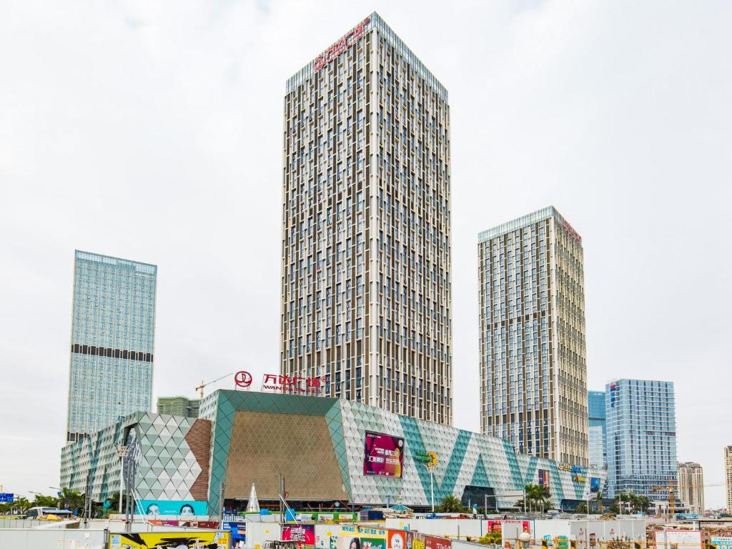 een groep hoge gebouwen in een stad bij Wind sleeping Color Hotel - GuangZhou CHIME LONG Line7&18Nancun Wanbo STN in Guangzhou