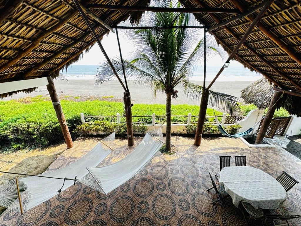 a hammock on a beach with a view of the ocean at Casa Pierre in Monterrico