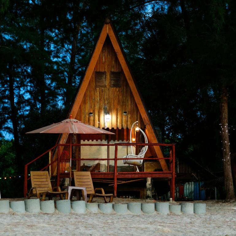 una casa sull'albero con sedie e ombrellone di Modtanoi Paradise Homestay a Ban Bu Lu