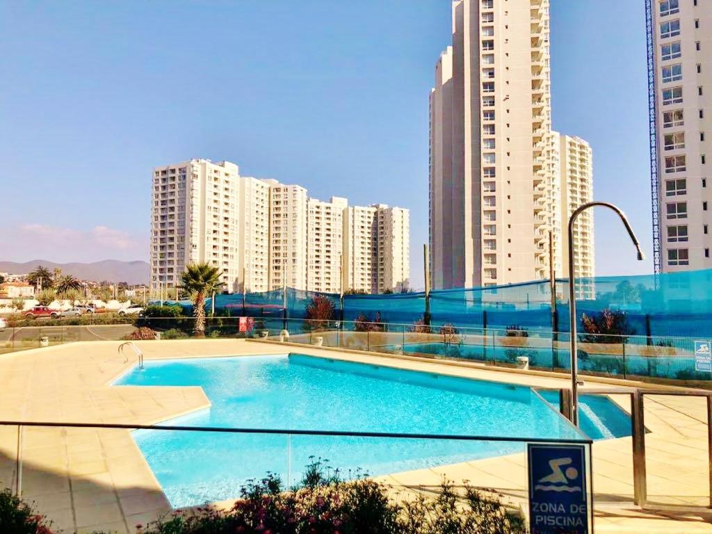 uma piscina numa cidade com edifícios altos em Apartamentos Marina del Sol em Coquimbo