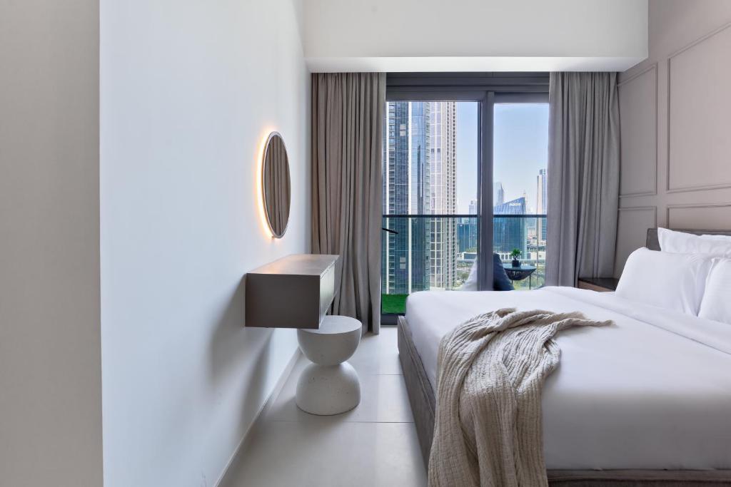 une chambre d'hôtel avec un lit et une grande fenêtre dans l'établissement Luxurious 4BR Apartment w/ Prime Burj Khalifa View, à Dubaï