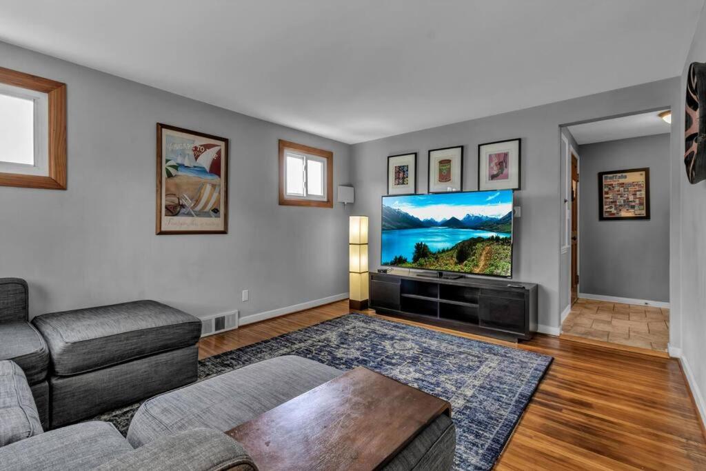 a living room with a couch and a flat screen tv at Gorgeous 2 Queen Bedroom Apartment in North Buffalo with 70 inch TV in Buffalo