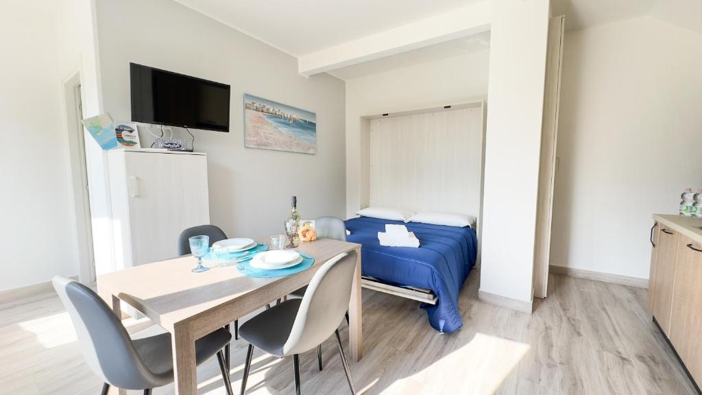 a small room with a dining table and a bed at Onda Blu House by Ca-Sa Check in Chioggia