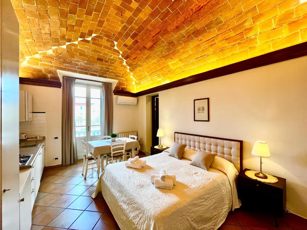 een slaapkamer met een groot bed en een bakstenen plafond bij Residence Internazionale in Pietrasanta