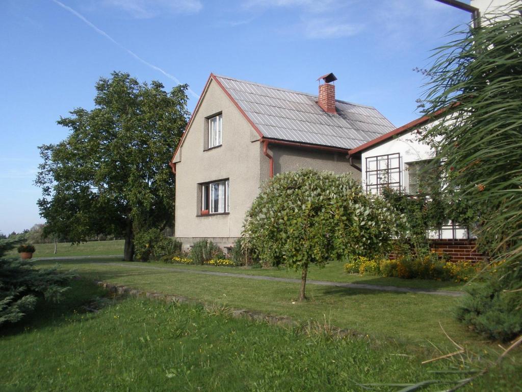 a white house with a tree in the yard at Ubytování u Přadků in Čeladná