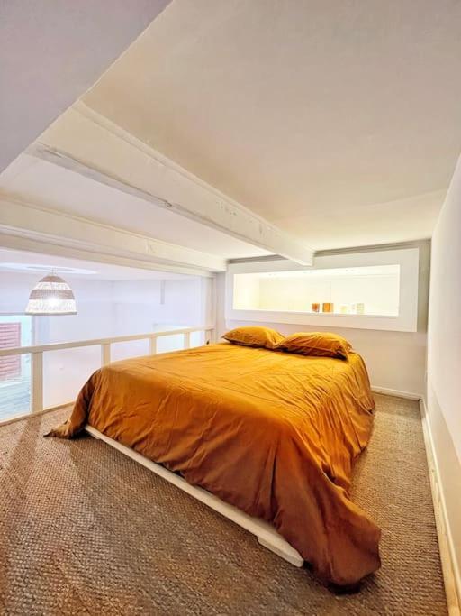 a bedroom with a large bed with an orange blanket at Appartement + terrasse à 5min à pied de la mer et du Vallon des auffes in Marseille
