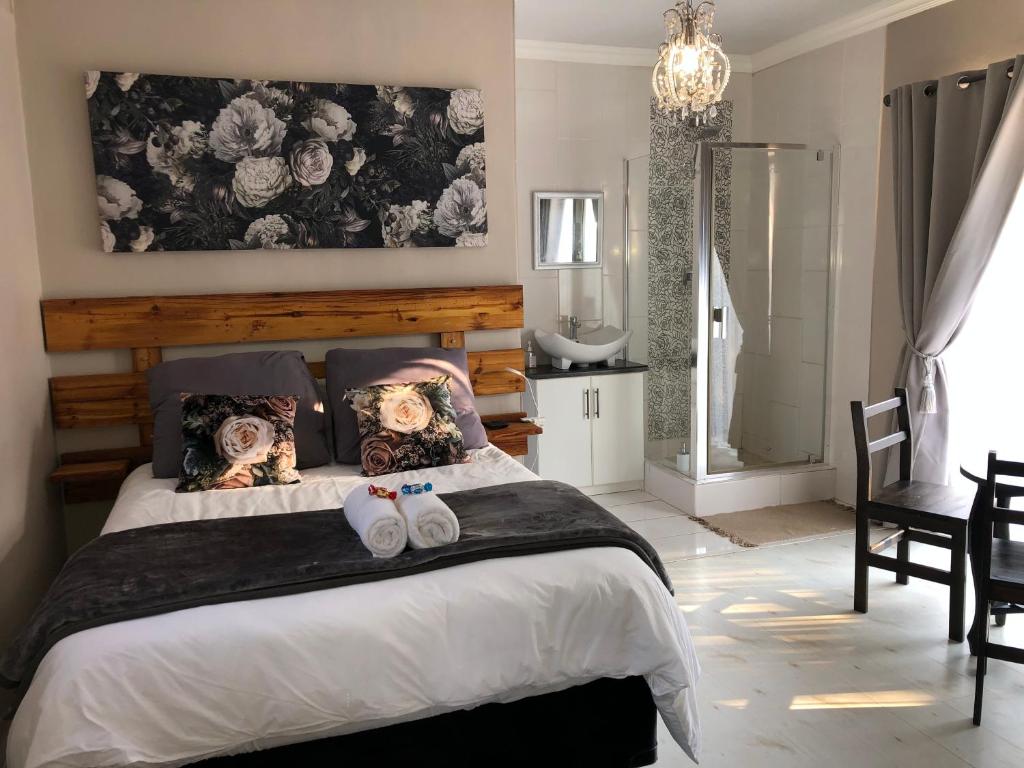 a bedroom with a large bed with shoes on it at Home@Harts in Hartswater
