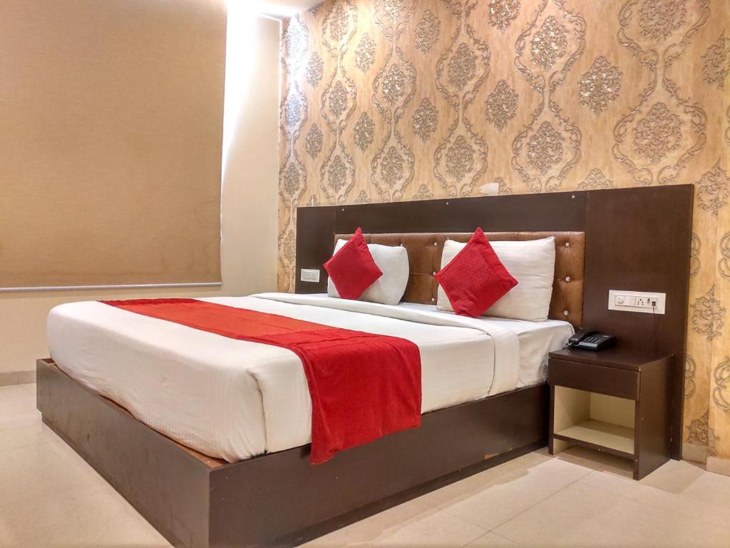een slaapkamer met een groot bed met rode kussens bij The Iconic Delhi Airport by Midway in New Delhi