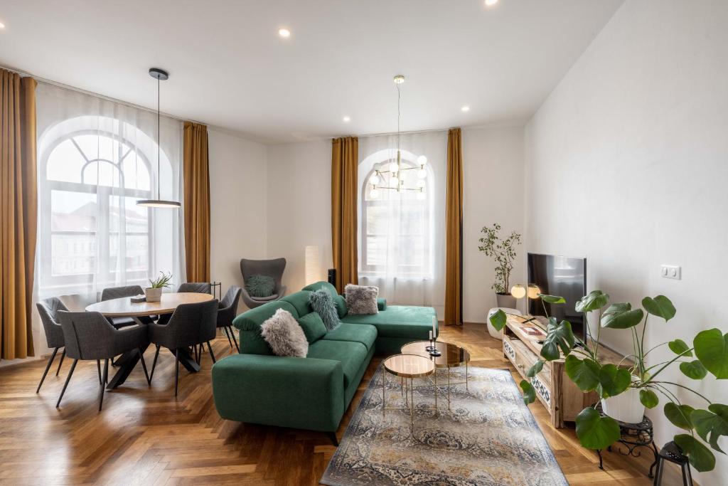 ein Wohnzimmer mit einem grünen Sofa und einem Tisch in der Unterkunft Apartmány Marienhof in Znojmo