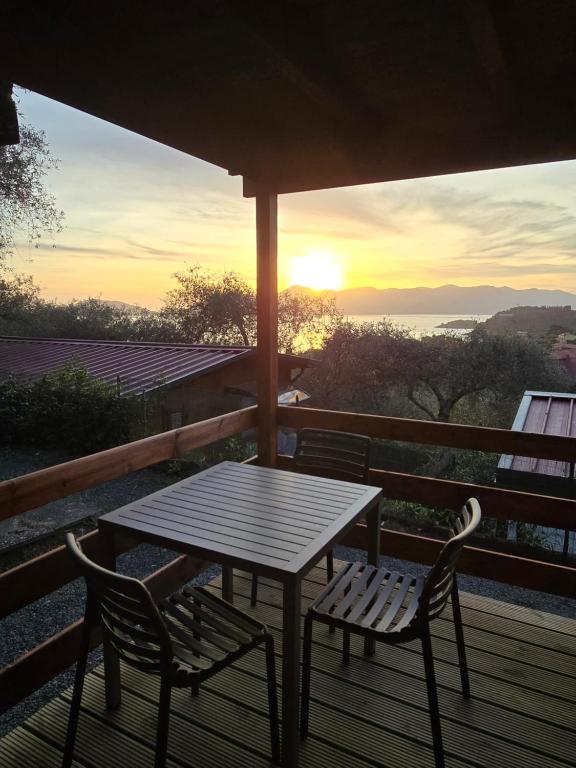 a table and chairs on a deck with the sunset at Campeggio Gianna Golfo dei Poeti in Lerici