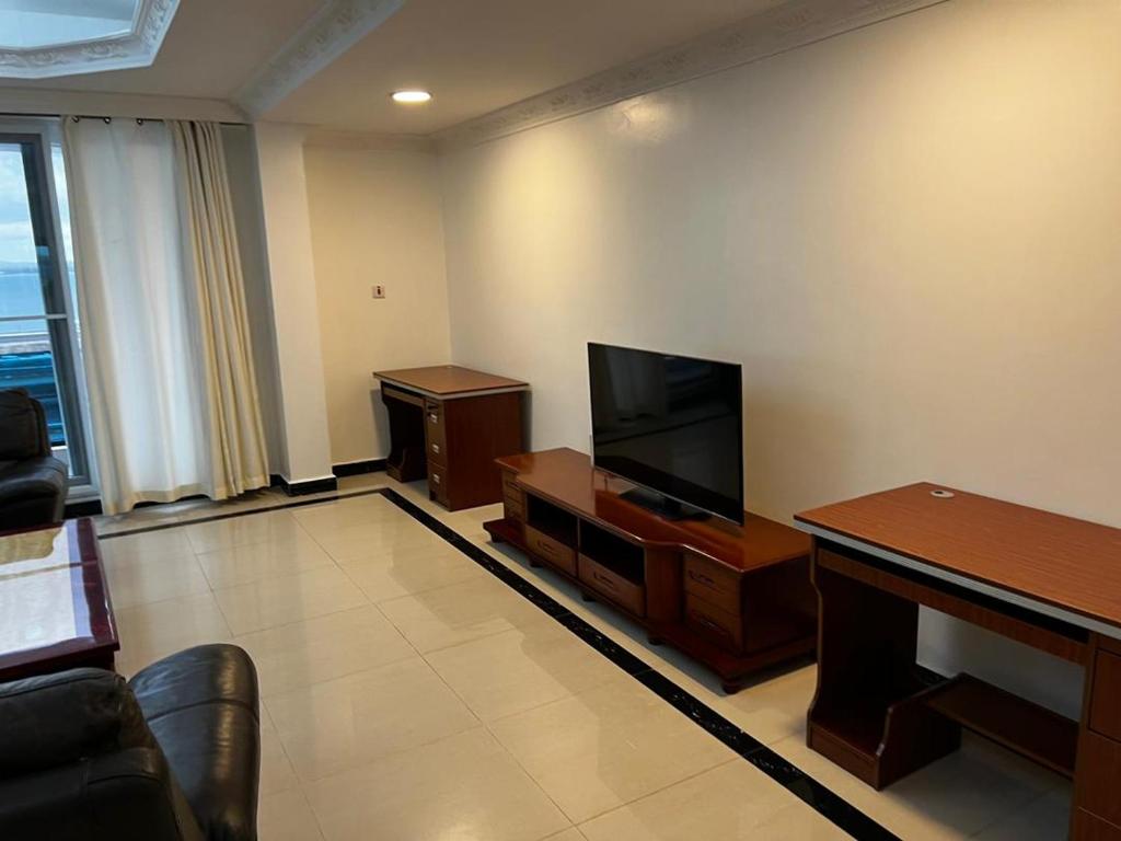 a living room with a flat screen tv and a couch at Chantel Sea View in Dar es Salaam