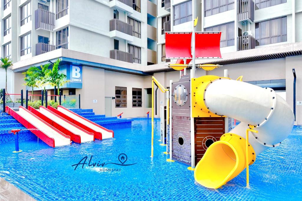 a water slide in a swimming pool in front of a building at Bali Residences 6-8pax I Water Park I 5minsJonkerSt Managed by Alviv Management in Melaka