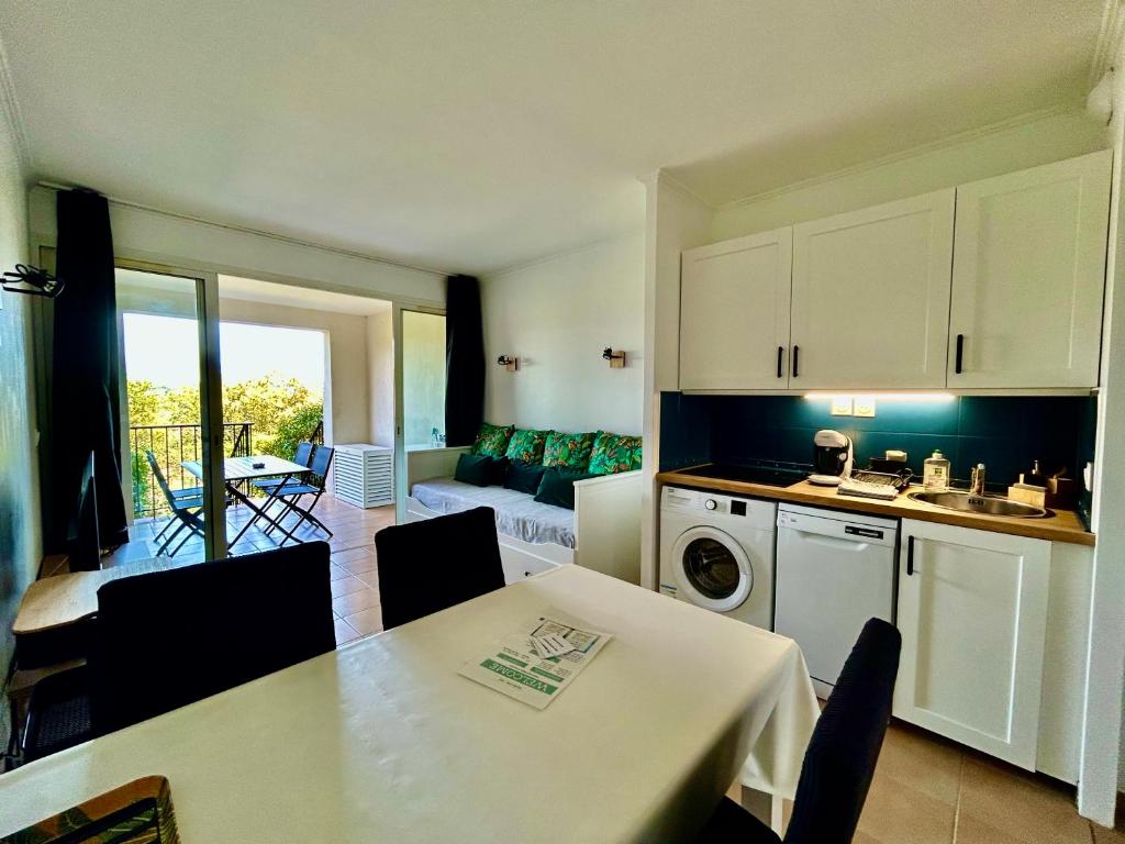 une cuisine et un salon avec une table et des chaises dans l'établissement Les Restanques 2036 rez jardin Jonquilles, à Grimaud