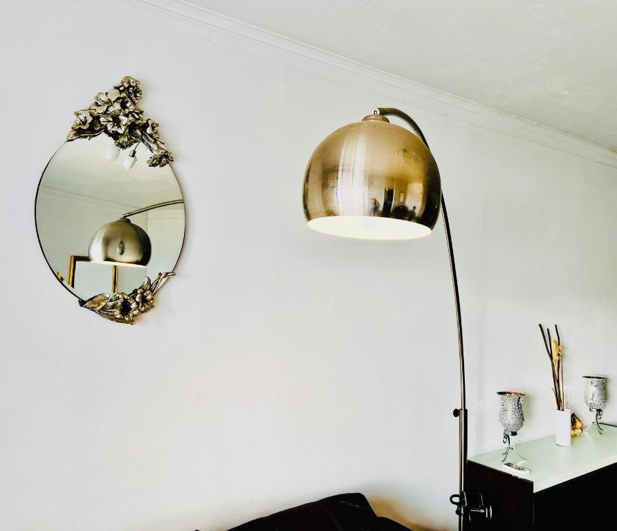 un espejo redondo en una pared junto a una lámpara en R2 Salina Seaview Retreat en Naxxar