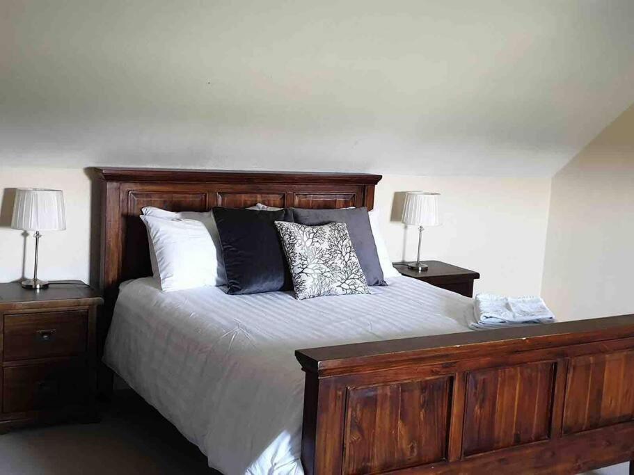 a bedroom with a large bed with two night stands at Shannonvale Cottage in Nenagh