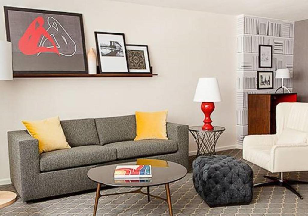 Lovely1BR Apartment in Midtown في نيويورك: غرفة معيشة مع أريكة وطاولة وكرسي