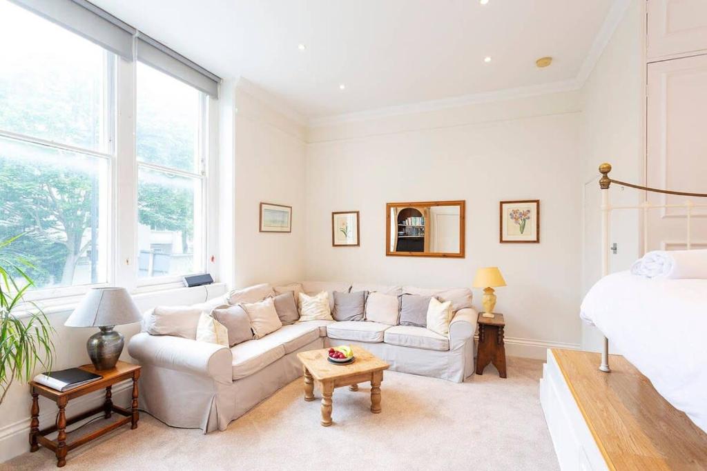 a living room with a couch and a bed at Charming Studio Apartment Near Clapham Common in London