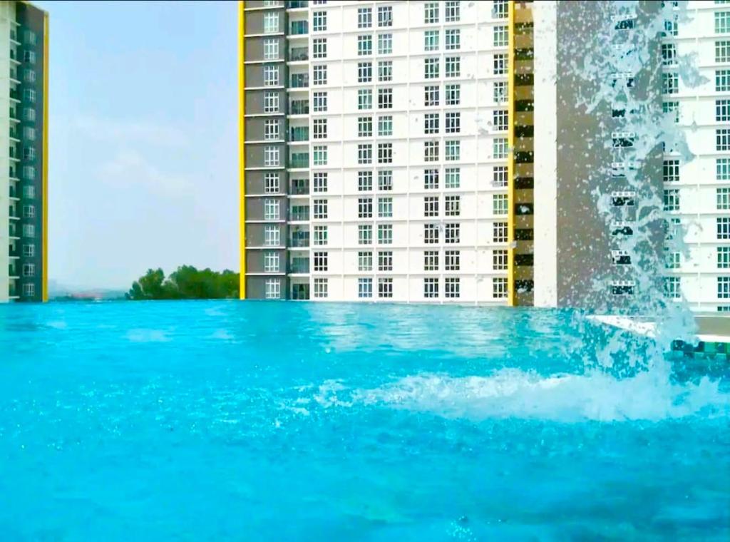 a fountain in a swimming pool in front of a building at Mesahill 2 Bedroom (Deluxe Queen) by DKAY in Nilai in Nilai