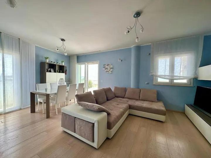 uma sala de estar com um sofá e uma sala de jantar em SIGISHOUSE em Fiumicino