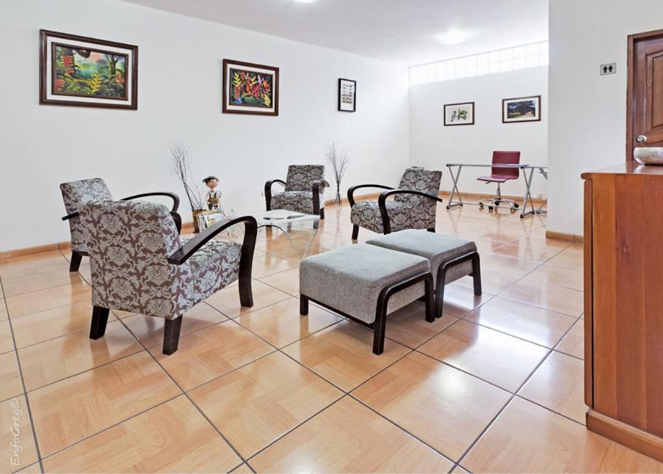ein Wohnzimmer mit Stühlen, einer Bank und einem Tisch in der Unterkunft Aviró Hotel in La Merced