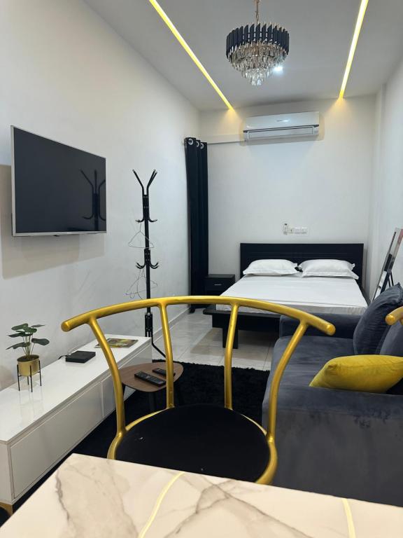 a bedroom with a bed and a tv on the wall at AD HOME in Lomé