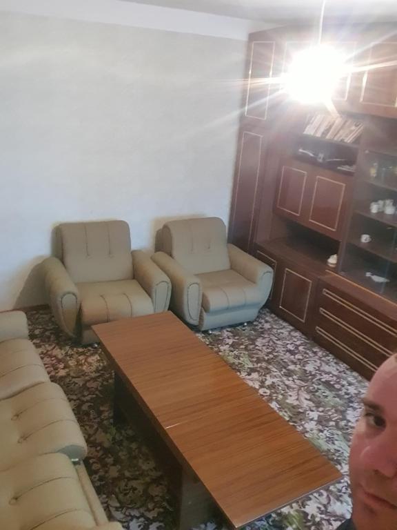 uma sala de estar com dois sofás e uma mesa em Къща за гости em Razgrad