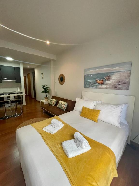 um quarto com uma grande cama branca com toalhas em CarreraHouses Brisa em Vigo