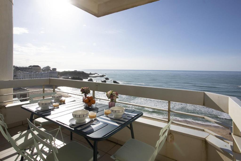 un balcon avec une table et une vue sur l'océan dans l'établissement Appartement Victoire vue mer - Welkeys, à Biarritz