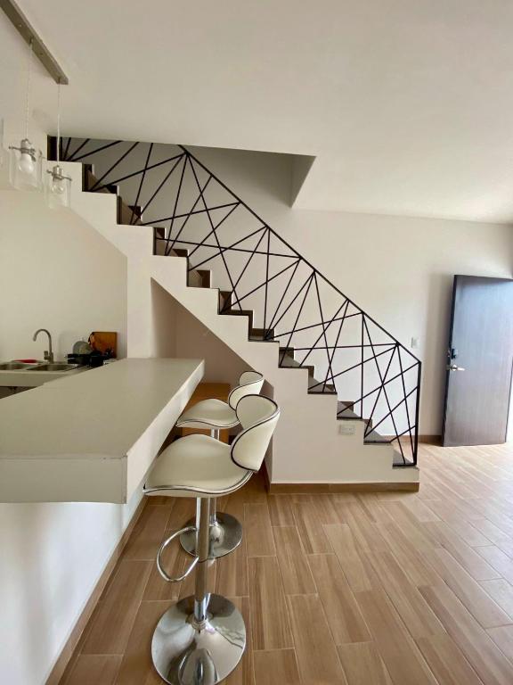 a room with a staircase with stools and a counter at Departamento Océano in La Paz