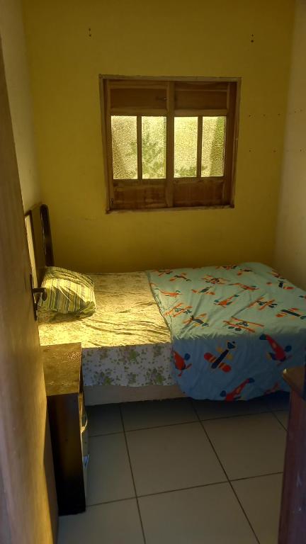 a small bedroom with a bed and a window at Alugo casa no vale do capao in Palmeiras