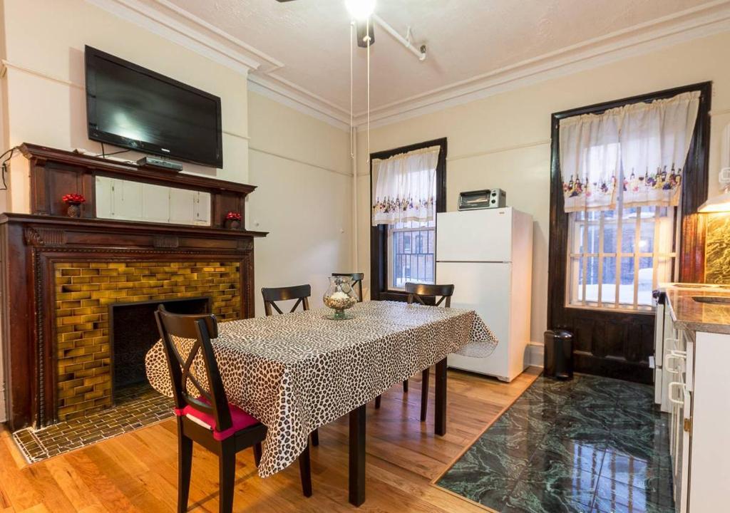 a dining room with a table and a fireplace at Comfortable One Bedroom Apartment in New York